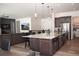 Open kitchen with a granite island, stainless steel appliances, and pendant lighting, connected to the living space at 5492 Woodroot Pt, Castle Rock, CO 80104