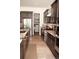 Modern kitchen featuring stainless steel appliances, granite countertops, dark wood cabinets, and walk-in pantry at 5492 Woodroot Pt, Castle Rock, CO 80104