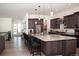Island kitchen featuring granite countertops, stainless steel appliances, and dark wood cabinetry at 5492 Woodroot Pt, Castle Rock, CO 80104