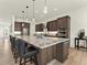 Spacious kitchen showcases dark wood cabinets, granite countertops, and a large central island with bar seating at 5492 Woodroot Pt, Castle Rock, CO 80104