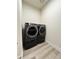 Modern laundry room with gray front-load washer and dryer set at 5492 Woodroot Pt, Castle Rock, CO 80104