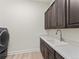 Functional laundry area featuring a sink, counter space, and overhead cabinets for convenient chores at 5492 Woodroot Pt, Castle Rock, CO 80104