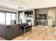 Open living room with fireplace, hardwood floors, and large windows for natural light at 5492 Woodroot Pt, Castle Rock, CO 80104