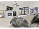 A beautifully decorated main bedroom with fireplace, ceiling fan, and a picturesque window view at 5492 Woodroot Pt, Castle Rock, CO 80104