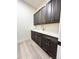 Mud room with dark brown cabinets, light walls, and light hardwood flooring at 5492 Woodroot Pt, Castle Rock, CO 80104