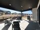 Covered patio with comfortable seating and a grill with a view of the surrounding community at 5492 Woodroot Pt, Castle Rock, CO 80104