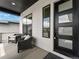 Inviting porch area with stylish seating, modern black door, and ample natural light at 5492 Woodroot Pt, Castle Rock, CO 80104