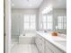 Luxurious bathroom featuring marble tile, a soaking tub, dual vanities, and a glass-enclosed shower at 26722 E Peakview Pl, Aurora, CO 80016