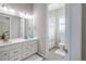 Well-lit bathroom featuring a double vanity, tile flooring, and a shower with a curtain at 26722 E Peakview Pl, Aurora, CO 80016