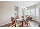 Formal dining room with chandelier, wood floors, shuttered windows, and view of the kitchen at 26722 E Peakview Pl, Aurora, CO 80016