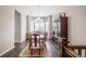 Bright dining room featuring chandelier, hardwood floors, shuttered windows, and a china cabinet at 26722 E Peakview Pl, Aurora, CO 80016