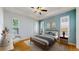 Inviting bedroom with hardwood floors, ceiling fan, tray ceiling, and plentiful light from shuttered windows at 6187 Reed Way, Arvada, CO 80003
