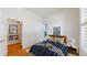 Bedroom featuring hardwood floors, plantation shutters, and a door to the hallway at 6187 Reed Way, Arvada, CO 80003