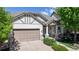 Charming home with a two-car garage, covered porch, and manicured landscaping under a bright blue sky at 6187 Reed Way, Arvada, CO 80003