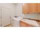 Convenient laundry room equipped with sink, storage cabinet, and included washer and dryer at 6187 Reed Way, Arvada, CO 80003