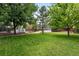 View of a large backyard with mature trees and two storage sheds on the property at 9315 Field Ln, Westminster, CO 80021