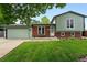 Charming home featuring a two-car garage, lush lawn, mature trees, and a brick and siding facade at 9315 Field Ln, Westminster, CO 80021
