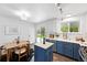 Eat-in kitchen features stainless appliances, an island, white and blue cabinets, and modern fixtures at 9315 Field Ln, Westminster, CO 80021