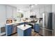 Eat-in kitchen features stainless appliances, an island, white and blue cabinets, and modern fixtures at 9315 Field Ln, Westminster, CO 80021