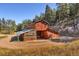 Rustic two-story barn features wood construction, an attached greenhouse, and complements the landscape at 60 N County Highway 67, Sedalia, CO 80135
