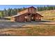Two-story barn with a rustic wood exterior and multiple access points in a rural setting at 60 N County Highway 67, Sedalia, CO 80135