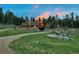 A view of the cabin with a large rock, green grass and trees in the background at 60 N County Highway 67, Sedalia, CO 80135