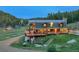 Stunning log home featuring a stone chimney, wood porch, and picturesque mountain setting at 60 N County Highway 67, Sedalia, CO 80135
