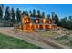 Inviting log home with warm lighting, featuring stone accents, a cozy porch, and nestled in a wooded landscape at 60 N County Highway 67, Sedalia, CO 80135