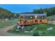 View of the cabin from the yard, with lots of windows, decks and a stone chimney at 60 N County Highway 67, Sedalia, CO 80135