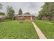 Well maintained backyard featuring a lush lawn, surrounded by mature trees and colorful landscaping, ideal for outdoor living at 1325 Geneva St, Aurora, CO 80010