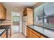 Bright kitchen with a window view, featuring a classic white refrigerator and tiled floors at 1325 Geneva St, Aurora, CO 80010