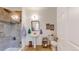 Bright bathroom features a tiled shower with glass door, pedestal sink, and neutral tile flooring at 4718 Raven Run, Broomfield, CO 80023