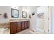 Bathroom featuring double sinks, vanity with storage, and tiled accents at 4718 Raven Run, Broomfield, CO 80023