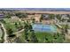 Aerial view of well-maintained tennis courts surrounded by green spaces and mature trees at 4718 Raven Run, Broomfield, CO 80023