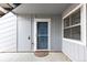 Exterior entrance featuring a blue door, gray siding, and a secure locking system at 7185 S Gaylord St # G13, Littleton, CO 80122