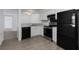 Modern kitchen featuring white cabinets, gray wood-look floors, and stainless steel appliances at 7185 S Gaylord St # G13, Littleton, CO 80122