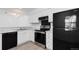 Bright kitchen features white cabinets, black appliances, and neutral countertops at 7185 S Gaylord St # G13, Littleton, CO 80122