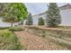 Landscaped backyard with a retaining wall, privacy fence, and rock features, enhancing the outdoor space at 5120 Perth St, Denver, CO 80249