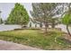Well-maintained backyard with lush green grass, mature trees, and a privacy fence for outdoor enjoyment at 5120 Perth St, Denver, CO 80249
