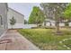 Spacious backyard featuring a brick patio, grassy lawn, and white privacy fence for serene outdoor living at 5120 Perth St, Denver, CO 80249