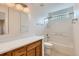 Bathroom with tub shower, oak vanity, and natural light fixture at 5120 Perth St, Denver, CO 80249
