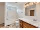 Bright bathroom featuring a combination tub and shower and oak vanity at 5120 Perth St, Denver, CO 80249