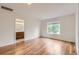 Bright bedroom featuring hardwood floors, a window, and an ensuite bathroom for comfortable living at 5120 Perth St, Denver, CO 80249