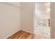 Walk-in closet with wire shelving, hardwood floors, and adjoining bathroom at 5120 Perth St, Denver, CO 80249