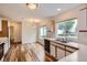 Bright kitchen with white cabinets, wood trim, stainless steel sink and modern wood flooring at 5120 Perth St, Denver, CO 80249