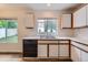 Kitchen featuring stainless steel sink, black dishwasher, white cabinets with wood trim, and modern flooring at 5120 Perth St, Denver, CO 80249