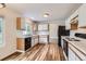 Well-lit kitchen featuring modern appliances, white cabinets, and sleek countertops with wood flooring at 5120 Perth St, Denver, CO 80249