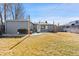 Expansive backyard with a well-manicured lawn, a gray house, a grill, and a concrete patio at 6835 W 55Th Pl, Arvada, CO 80002