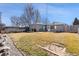 Spacious backyard featuring a grassy lawn, a gray house, a picnic table, and a patio seating area at 6835 W 55Th Pl, Arvada, CO 80002