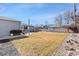 Large backyard showcasing a lawn, gray house, wooden fence, patio area, and a mature tree at 6835 W 55Th Pl, Arvada, CO 80002